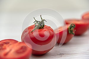 Red tomatoes on the white wood table.