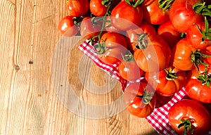 Red tomatoes on wooden background. Fresh vegetables top view with copy space for text. Flat lay. The concept of the harvest, veget