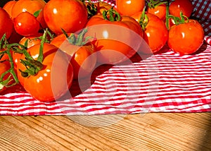 Red tomatoes on wooden background. Fresh vegetables top view with copy space for text. Flat lay. The concept of the harvest, veget