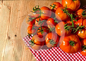 Red tomatoes on wooden background. Fresh vegetables top view with copy space for text. Flat lay. The concept of the harvest, veget