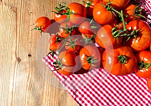 Red tomatoes on wooden background. Fresh vegetables top view with copy space for text. Flat lay. The concept of the harvest, veget