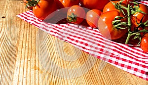 Red tomatoes on wooden background. Fresh vegetables top view with copy space for text. Flat lay. The concept of the harvest, veget