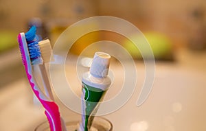 red toothbrush, green toothpaste and white sink