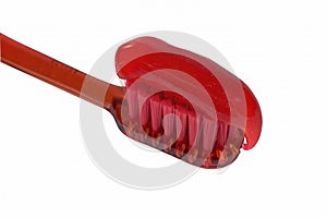 Red toothbrush with red toothpaste isolate on a white background close-up.