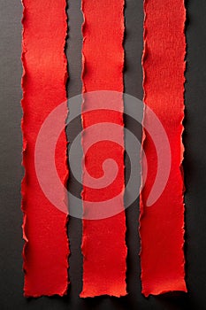 Red Torn Paper Strips on Black Background