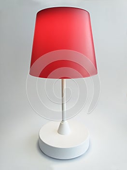 Red Touch Table Lamp turned on with warm light isolated on white background. Interior lighting and home decoration design object