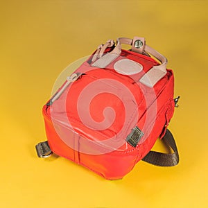 Red tourist backpack on a yellow background