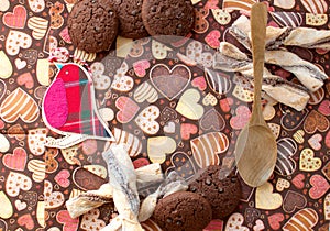 Red toy bird and cookies on dark napkin with image of hearts