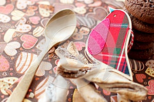 Red toy bird and cookies on dark napkin with image of hearts