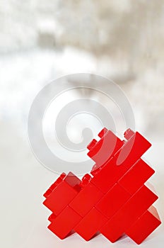 Red toy blocks heart on blurred background