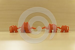 Red toy camels standing in two rows against each other. Abstract divorce or stepfamily concept. photo