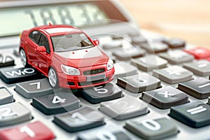 Red toy car on calculator, auto tax and financing, insurance and loans, concept of savings money on vehicle purchase.