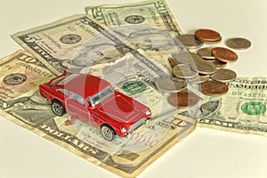 Red toy car and dollar banknotes