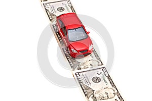 Red toy car on the money road, isolated on white