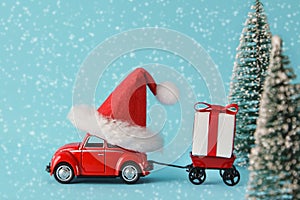 Red toy car with trailer delivering Christmas or New Year gifts. Preparing for Christmas. Copy space