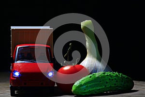 Red toy car vegetables dark background