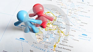 A red toy couple standing on the island of Hoy on a map of Scotland