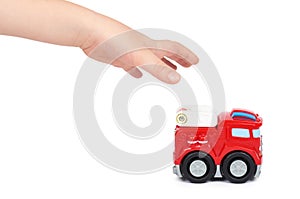 Red toy firefighter car with kid hand, isolated on white background, fire truck engine