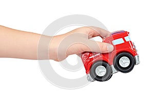 Red toy firefighter car with kid hand, isolated on white background, fire truck engine