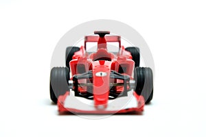 Red toy motor racing car, front view on white background.