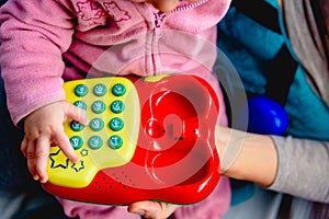 Red toy phone to entertain a baby.