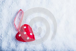 Red toy suave heart on a frosty white snow background. Love and St. Valentine concept.