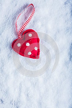 Red toy suave heart on a frosty white snow background. Love and St. Valentine concept. photo