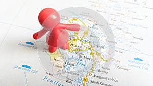 A red toy woman standing on the island of Hoy on a map of Scotland