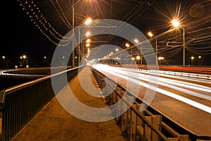 Red tracks from car headlamps on the bridge at night