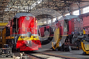 Red traction locomotives on serviced at a repair depot