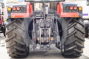 Red tractor with bif black wheels. rear view