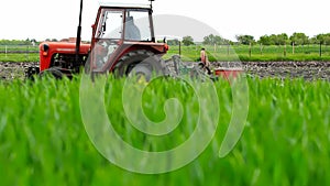 Red tractor in a field planting corn