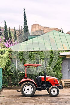 Red tractor in the garden. National Botanical Garden in Tbilisi.