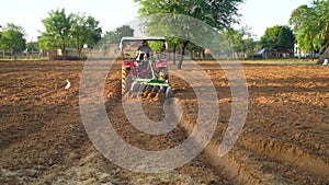 Red tractor plowing in autumn, farmer plowing stubble field in tractor preparing plows the land, agricultural works at farmland