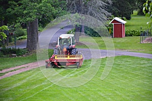 Red Tractor Pulling Disco Across Dirt Path