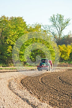 Red tractor sows the seed