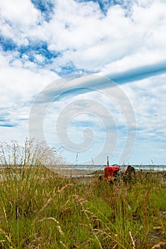 Red tractor under the clouds