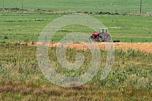 A red tractor working in a field