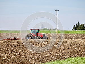 Red Tractor Works the Ground