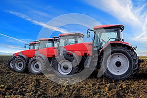 Red tractors on field