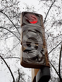 Red traffic light burned out after riots during a street demonstration.