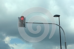 Red traffic light on a cloudy sky background with copy space for your text