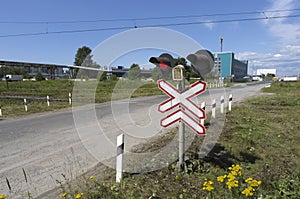 Red traffic light at the crossroads of the road and the railway