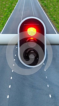 Red traffic light with empty highway on background, concept for stop, caution and pessimism