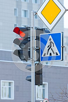 Red traffic light, pedestrian crosswalk and main road signs