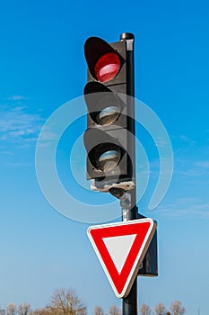 Red traffic light with yield sign