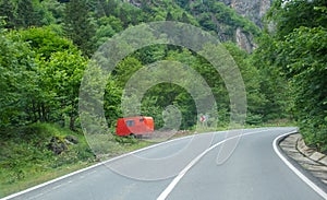 Red trailer near the way at forest