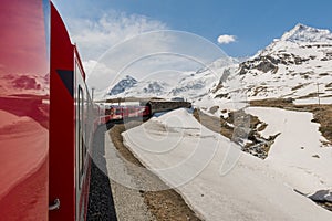 Red train from the company tunneling in the Alps.