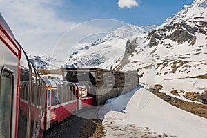 Red train from the company tunneling in the Alps.