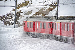 Red train in the snow in swiss alps